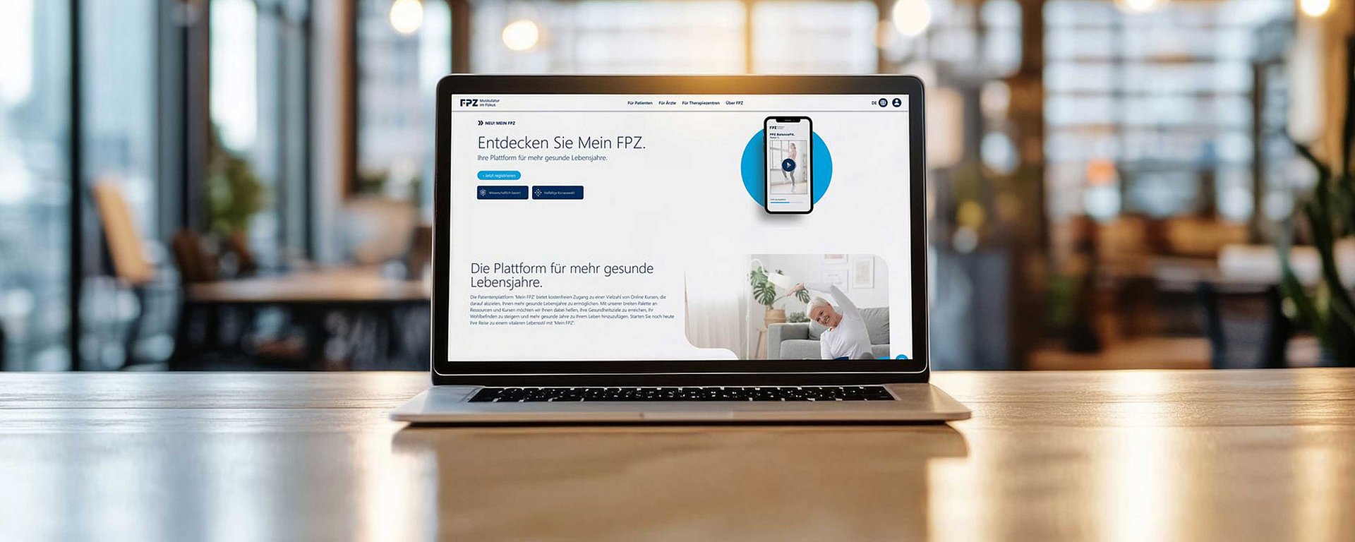 Auf einem Laptop, der auf einem Holztisch steht, ist eine deutschsprachige Website in einem modernen, hellen Arbeitsbereich zu sehen.