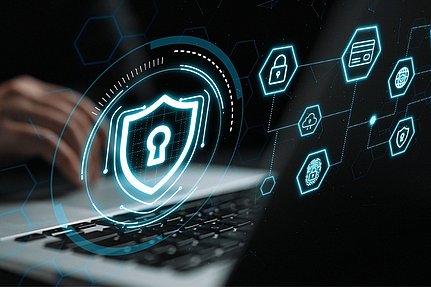 Eine Person, die auf einem Laptop tippt, auf dem digitale Sicherheitssymbole zu sehen sind, darunter ein Schloss, ein Schutzschild, ein Fingerabdruck und eine Kreditkarte, die für Cybersicherheit und Datenschutzmaßnahmen stehen.
