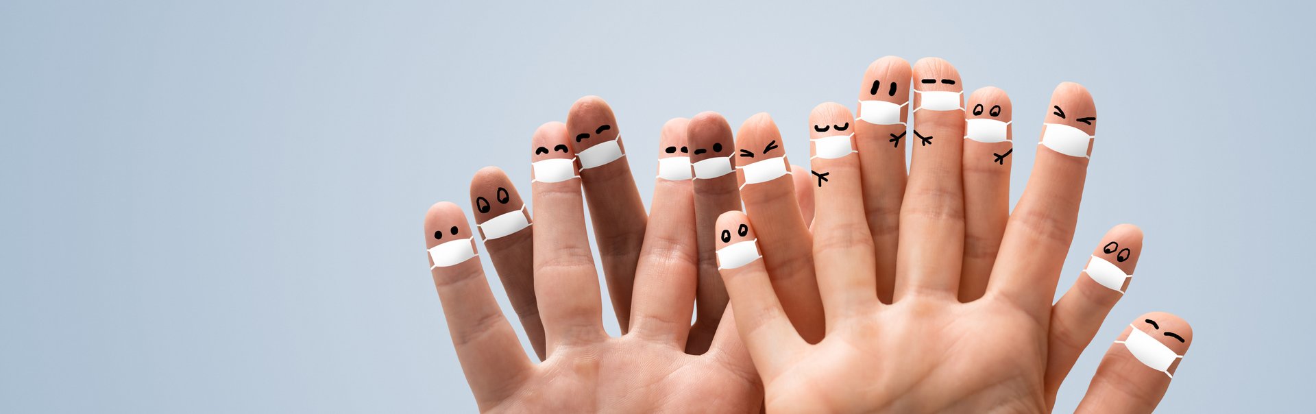 Viele Finger sind mit einem Munschutz und Augen bemalt.