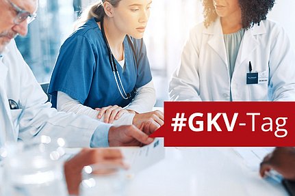 Drei medizinische Fachkräfte im Gespräch, im Vordergrund ein rotes Banner mit der Aufschrift #GKV-Tag.