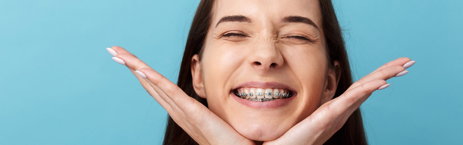 Eine junge Frau mit Zahnspange lacht.